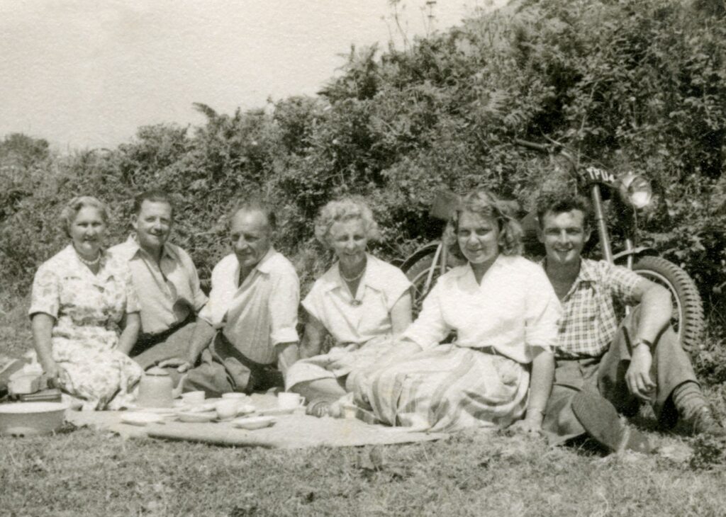 grayscale photo of group of men sitting on grass